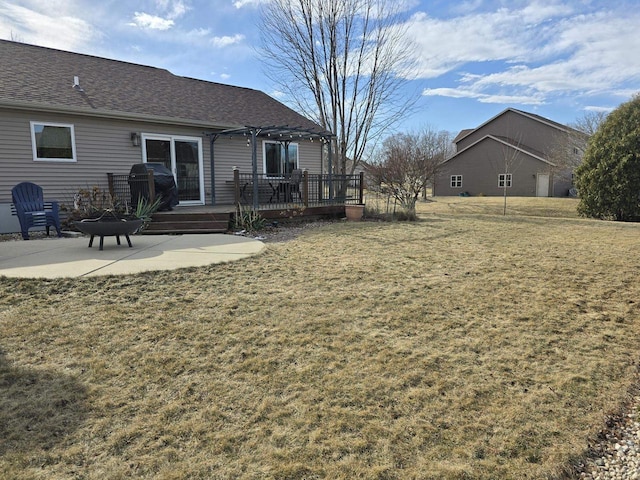 view of yard with a patio area, an outdoor fire pit, a deck, and a pergola