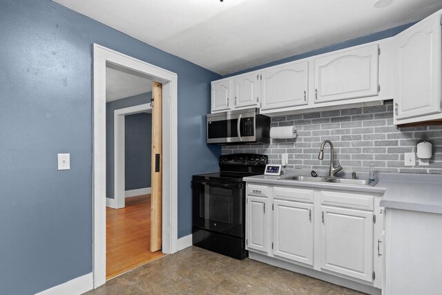 1033 Vernon St, Stoughton, WI 53589 - kitchen featuring tasteful backsplash, white cabinetry, black electric range oven, and sink