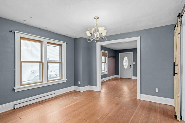 1033 Vernon St, Stoughton, WI 53589 - interior space with hardwood / wood-style flooring, a baseboard radiator, a barn door, and plenty of natural light
