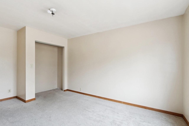 unfurnished bedroom featuring light colored carpet and a closet