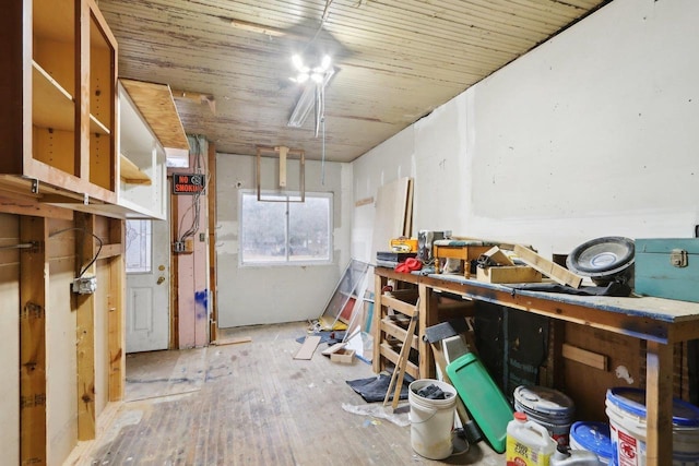 interior space with a workshop area, light hardwood / wood-style floors, and wood ceiling