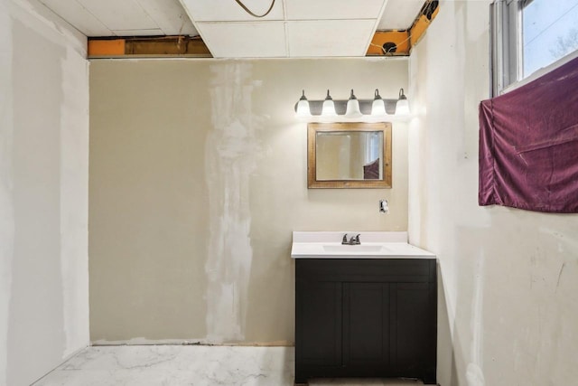 bathroom featuring a paneled ceiling and vanity