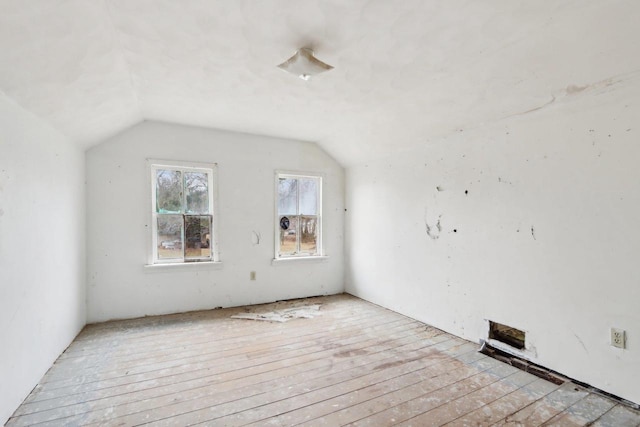 additional living space with light hardwood / wood-style floors and lofted ceiling