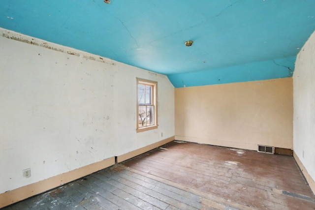 unfurnished room featuring lofted ceiling and hardwood / wood-style floors