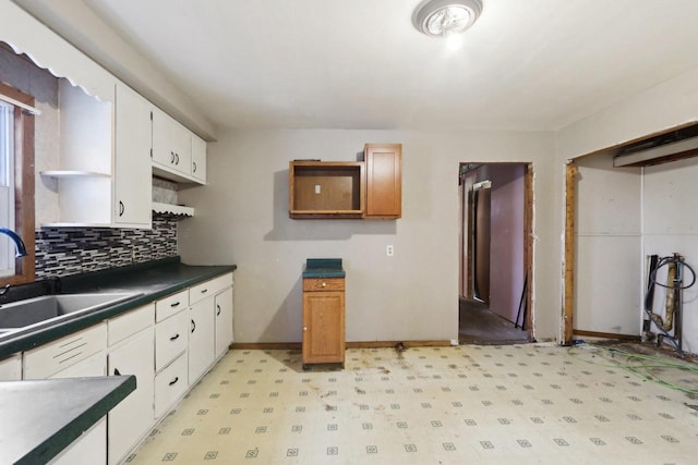 kitchen featuring white cabinets, sink, and backsplash