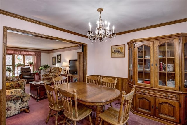 carpeted dining space with crown molding, a notable chandelier, and wood walls