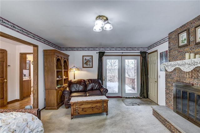 bedroom with a brick fireplace, light colored carpet, access to exterior, and french doors