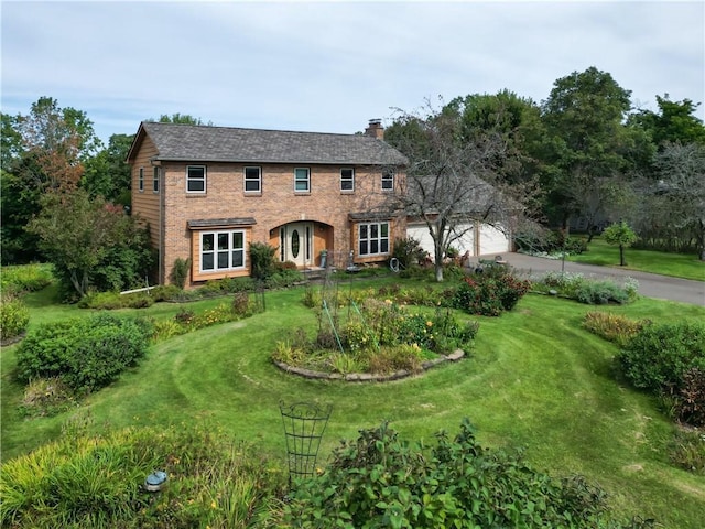 view of front of property featuring a garage and a front lawn