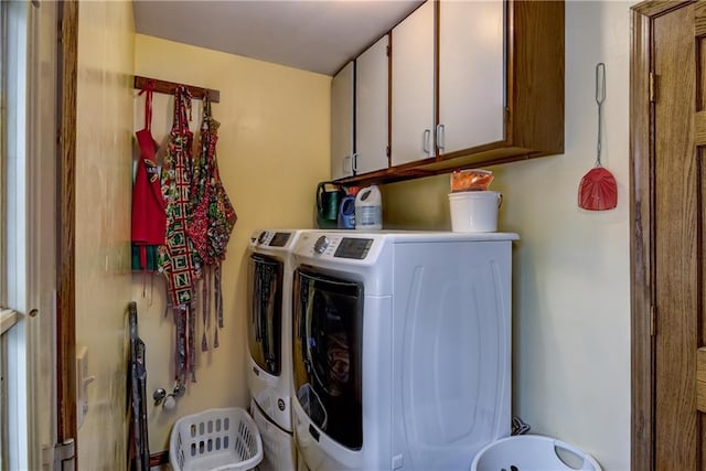 laundry room featuring independent washer and dryer and cabinets