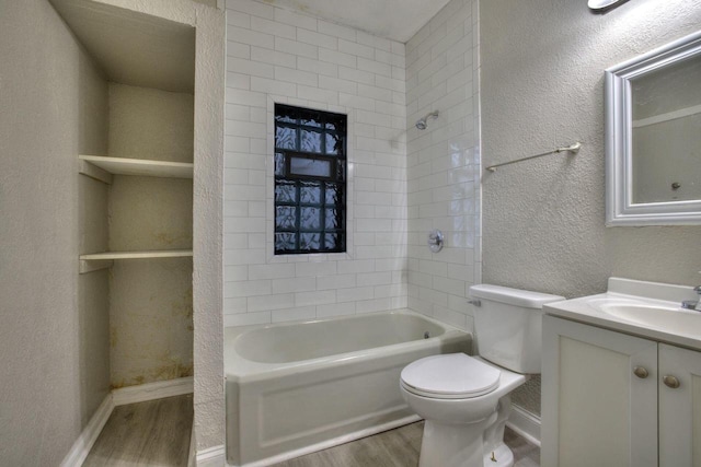 full bathroom featuring vanity, hardwood / wood-style floors, tiled shower / bath, and toilet