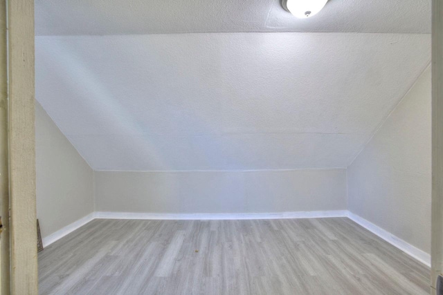 bonus room featuring lofted ceiling and light hardwood / wood-style flooring