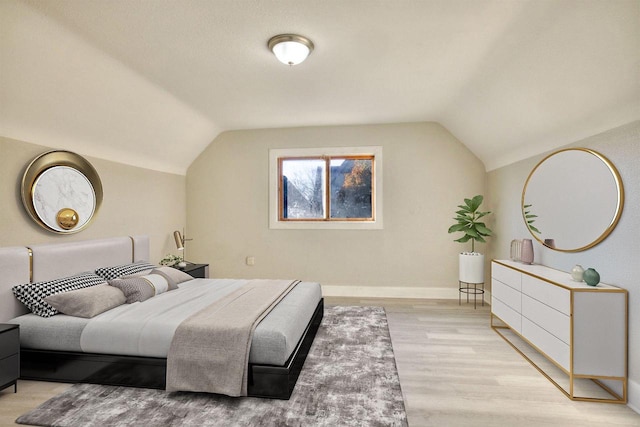 bedroom featuring vaulted ceiling and light hardwood / wood-style flooring