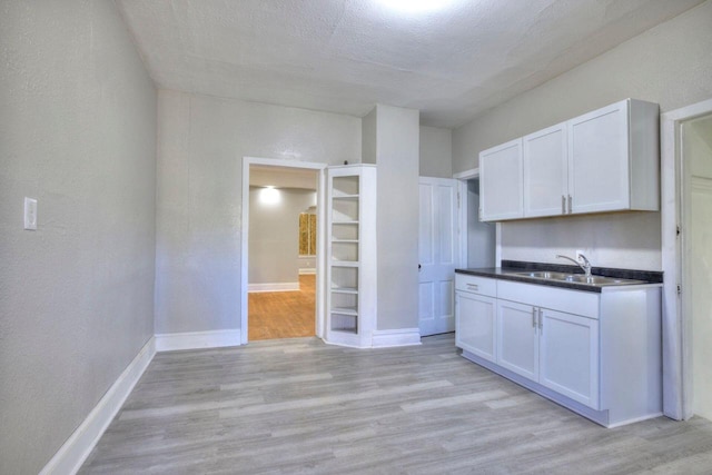 kitchen featuring sink, light hardwood / wood-style flooring, and white cabinets