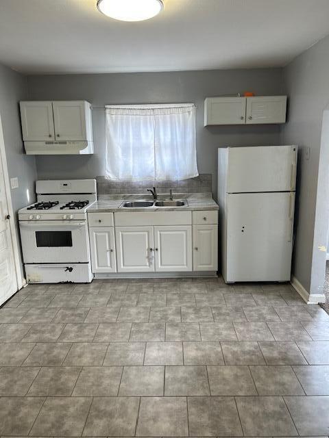 kitchen featuring white cabinetry, sink, and white appliances