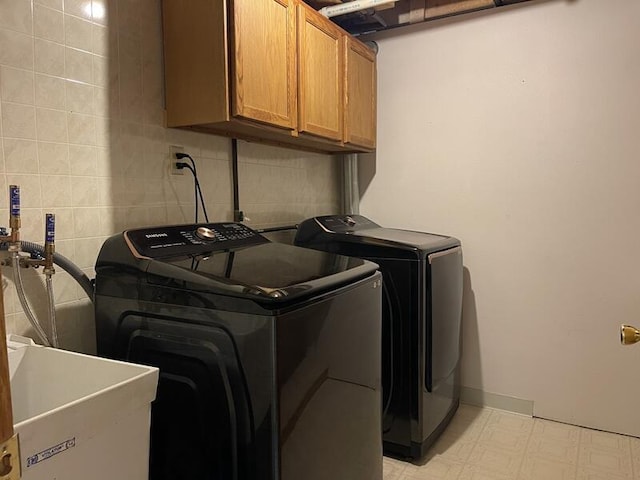 washroom with cabinets, sink, and washer and dryer