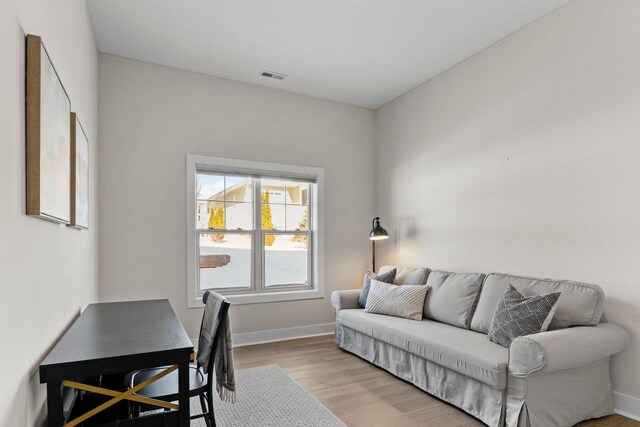 office space featuring light wood-style floors, baseboards, and visible vents