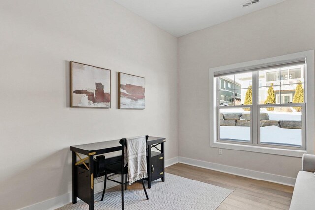 office area featuring visible vents, light wood-style flooring, and baseboards