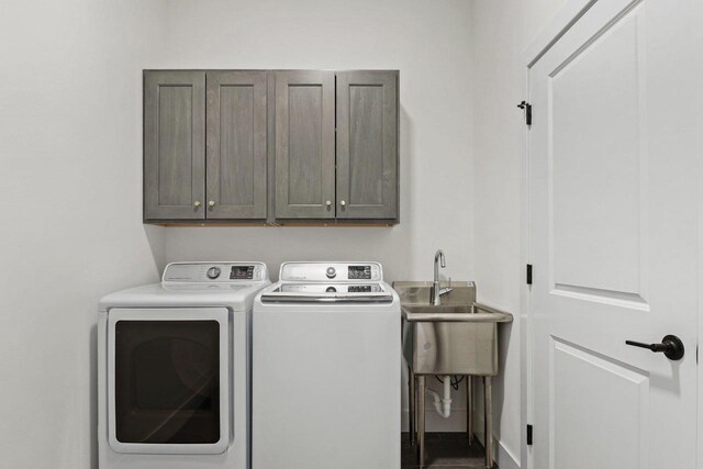 laundry area with cabinet space, a sink, and independent washer and dryer