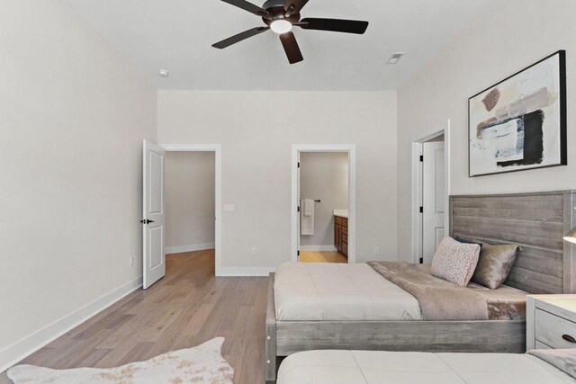 bedroom with ceiling fan, connected bathroom, visible vents, baseboards, and light wood-type flooring