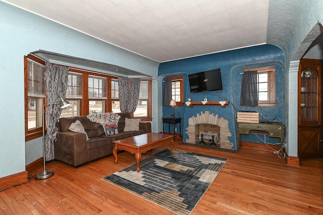 living room with hardwood / wood-style flooring and a stone fireplace