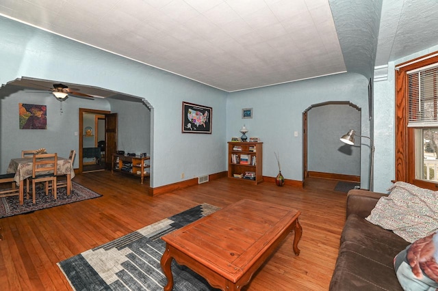 living room with wood-type flooring and ceiling fan