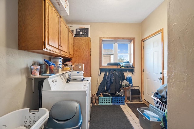 laundry area featuring cabinets, independent washer and dryer, and light tile patterned flooring