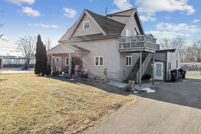 view of property exterior with a yard and a balcony