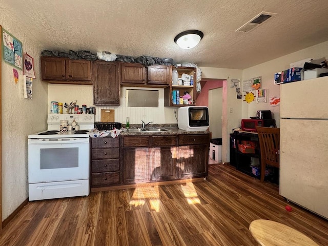 kitchen featuring white appliances, dark hardwood / wood-style floors, sink, and a textured ceiling