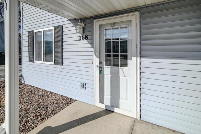 view of exterior entry with a patio