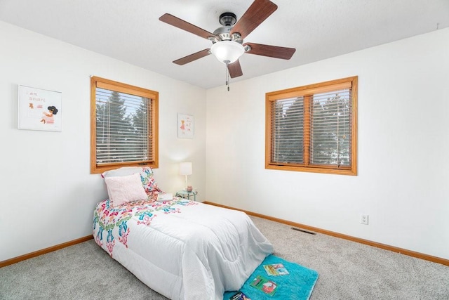 carpeted bedroom with multiple windows and ceiling fan