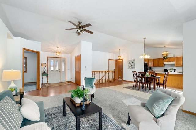 living room featuring lofted ceiling, ceiling fan with notable chandelier, and light colored carpet