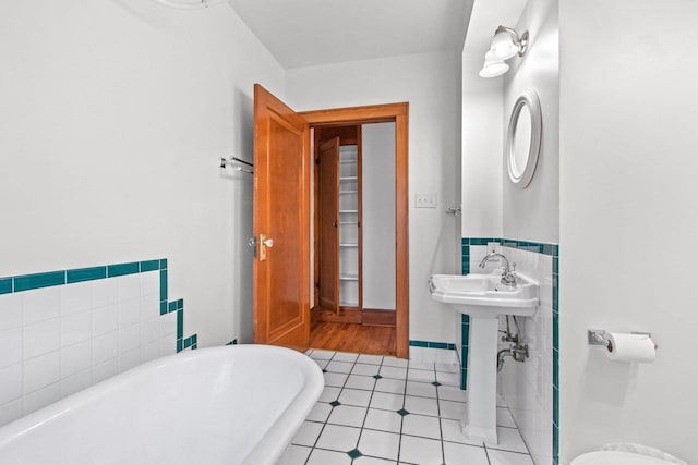 bathroom featuring tile patterned floors, sink, and a tub