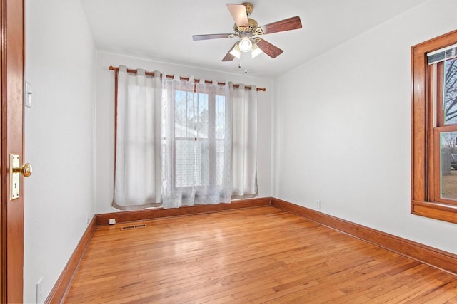 empty room with ceiling fan and light hardwood / wood-style floors