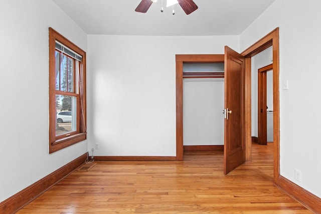 unfurnished bedroom featuring light hardwood / wood-style flooring, ceiling fan, and a closet