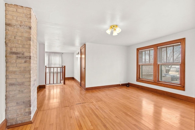 spare room featuring light hardwood / wood-style floors and a healthy amount of sunlight