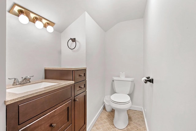 bathroom with vanity, vaulted ceiling, and toilet