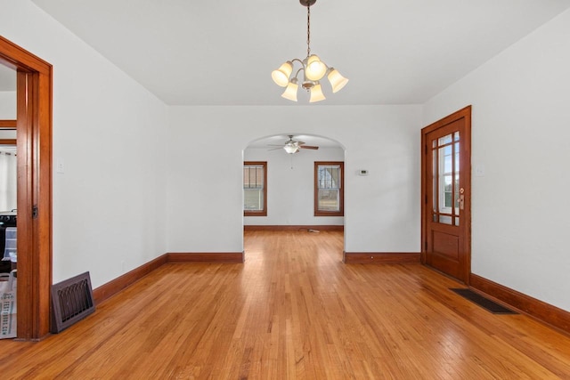 interior space featuring ceiling fan with notable chandelier and light hardwood / wood-style floors