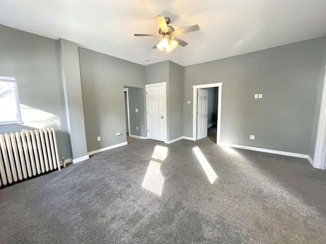 interior space featuring ceiling fan, radiator heating unit, and dark carpet