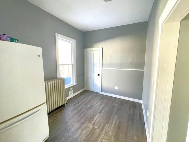 interior space with dark wood-type flooring and radiator heating unit