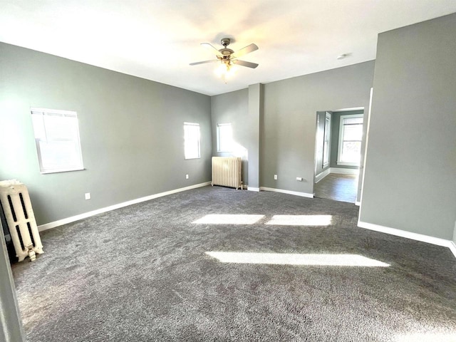 carpeted spare room with ceiling fan and radiator