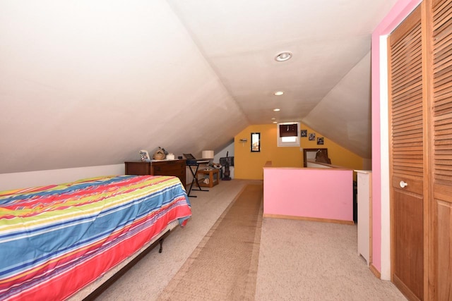 bedroom featuring vaulted ceiling, light colored carpet, and a closet