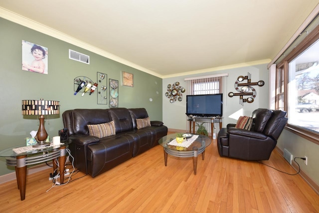 living room with crown molding and light hardwood / wood-style floors