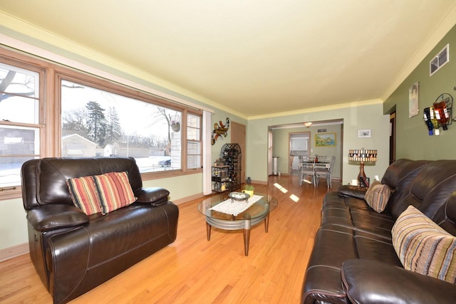 living room featuring crown molding and light hardwood / wood-style floors