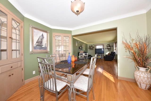 dining room featuring ornamental molding, light hardwood / wood-style flooring, and a wealth of natural light