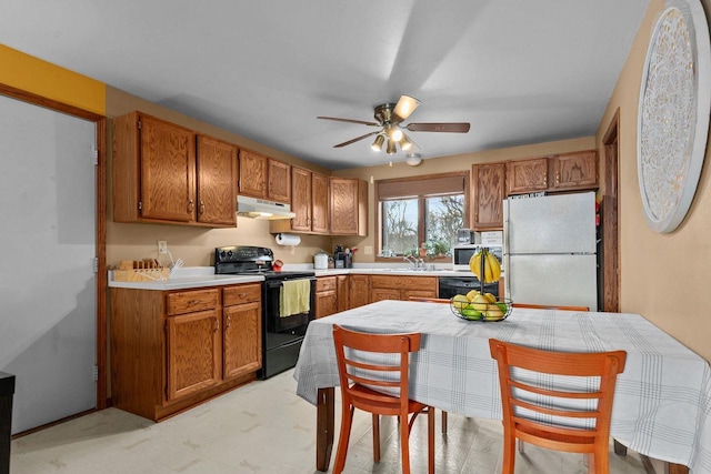 kitchen featuring ceiling fan, black electric range oven, sink, and white fridge