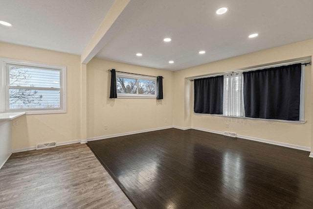 unfurnished room with beamed ceiling and hardwood / wood-style floors