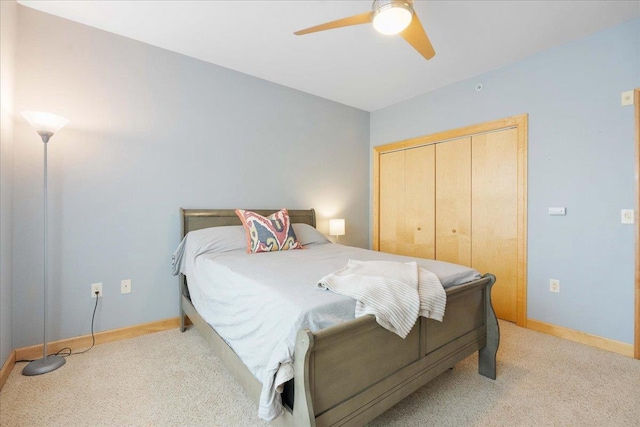 carpeted bedroom featuring ceiling fan and a closet