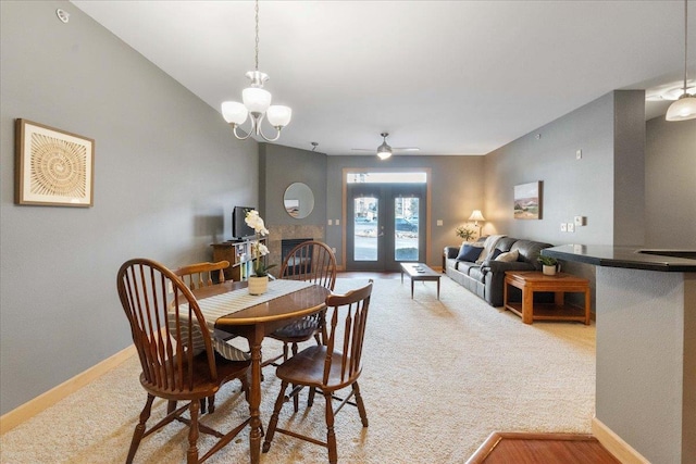 dining room featuring a notable chandelier, a fireplace, and light colored carpet