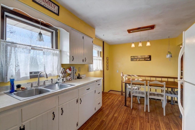 kitchen featuring sink, decorative light fixtures, white cabinets, and white refrigerator