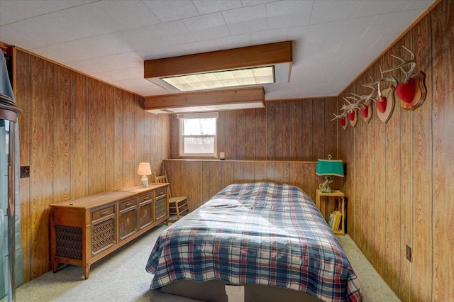 carpeted bedroom featuring wood walls